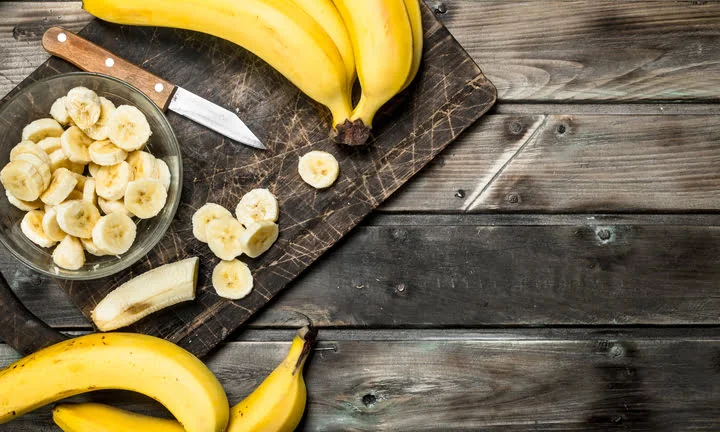 bananas and banana slices in a plate on a black