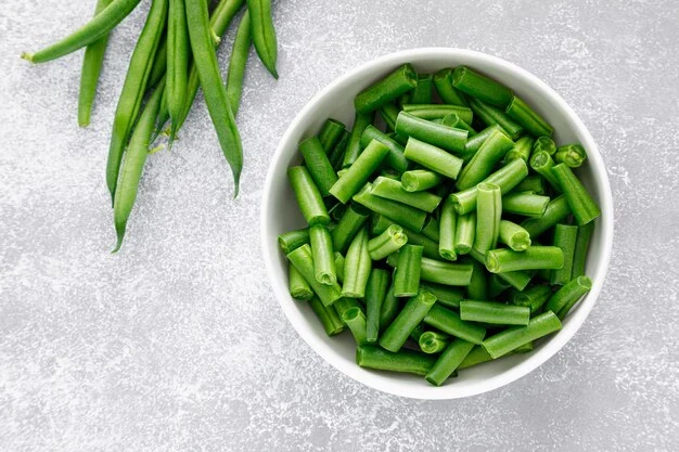 Green beans in a ceramic bowl on white background